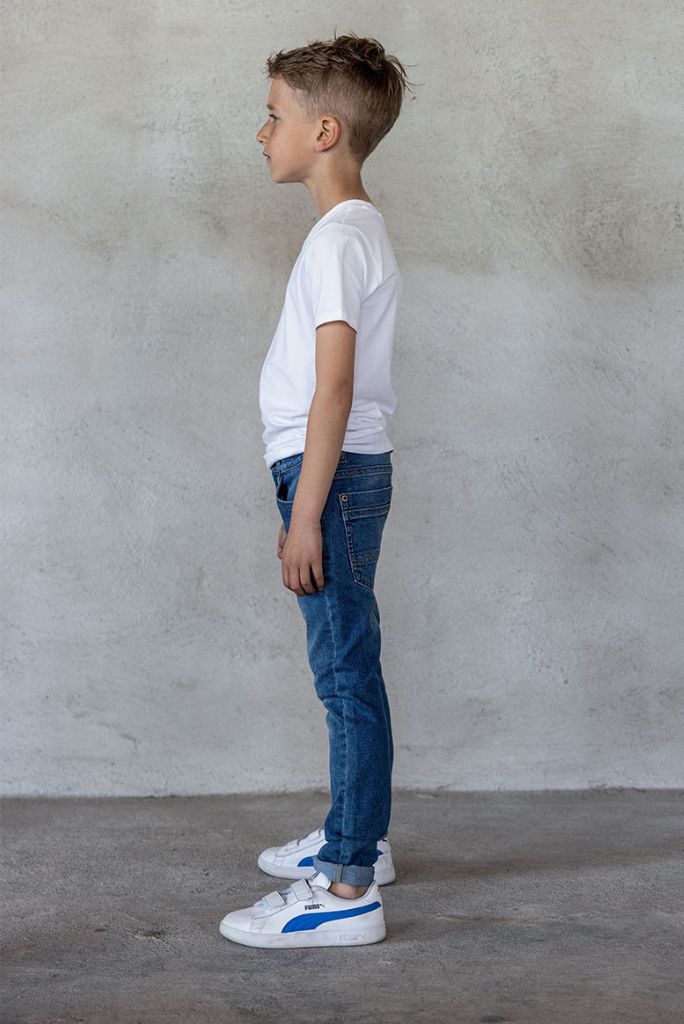 Side view of the boy wearing the skinny jeans in medium used wash by TYGO & vito