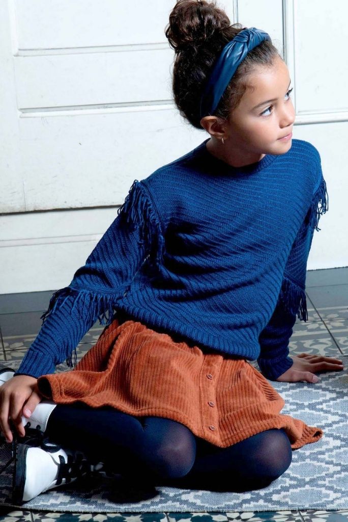 Girl sitting on the floor and wearing the blue knit jumper by B.Nosy