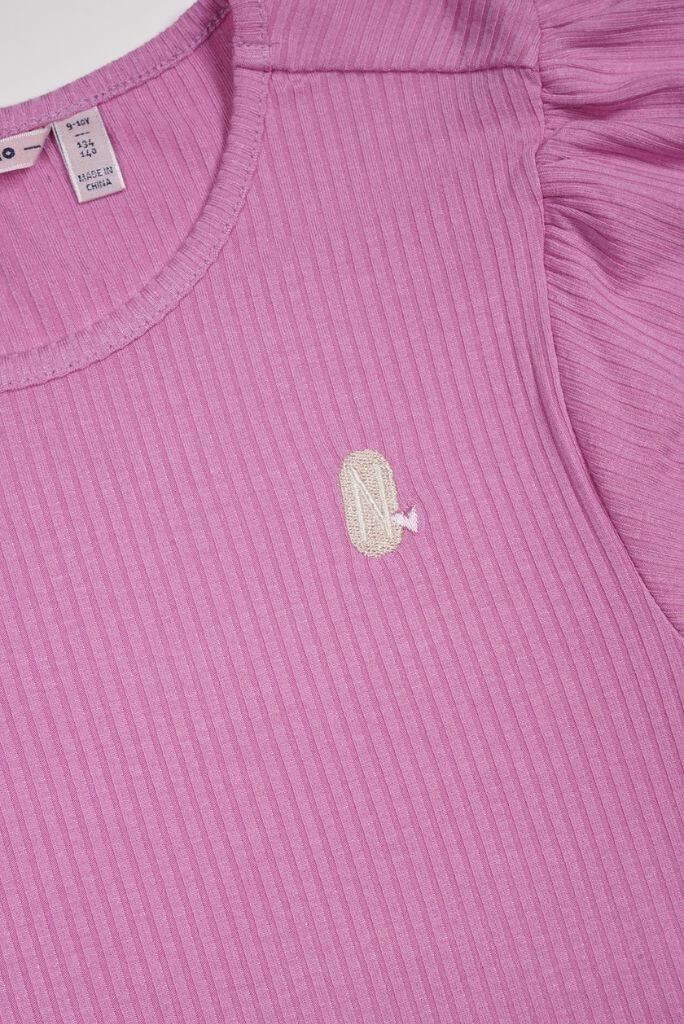 Close-up of a pink ribbed garment with a small logo on a plain background