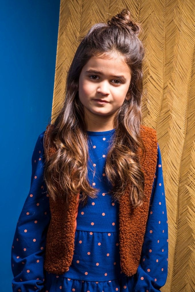 Close view of the girl wearing the blue polka dot long sleeve dress by B.Nosy
