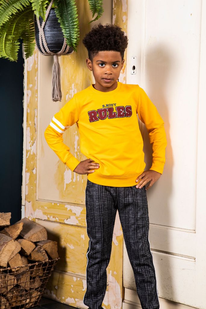 Boy wearing the check pants with a yellow jumper