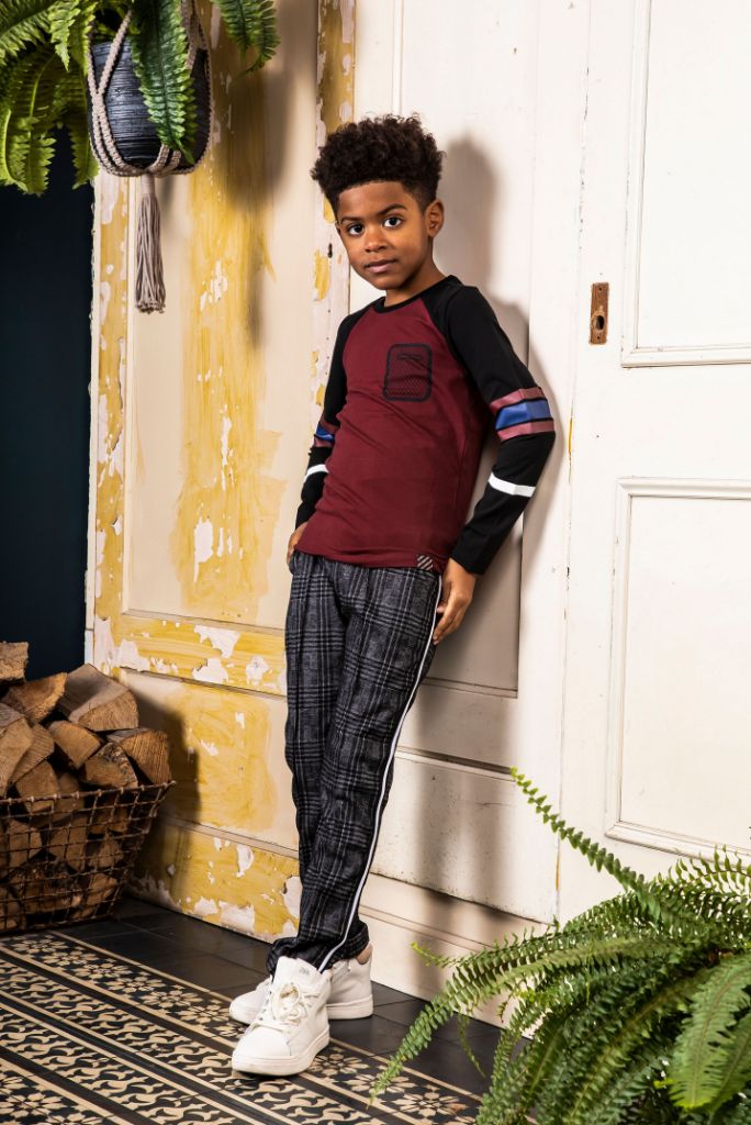 Boy wearing the check pants with a red top