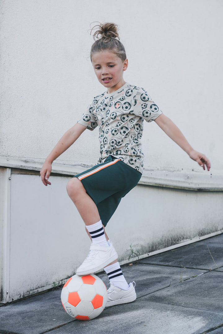 Child playing with a soccer ball on a rooftop