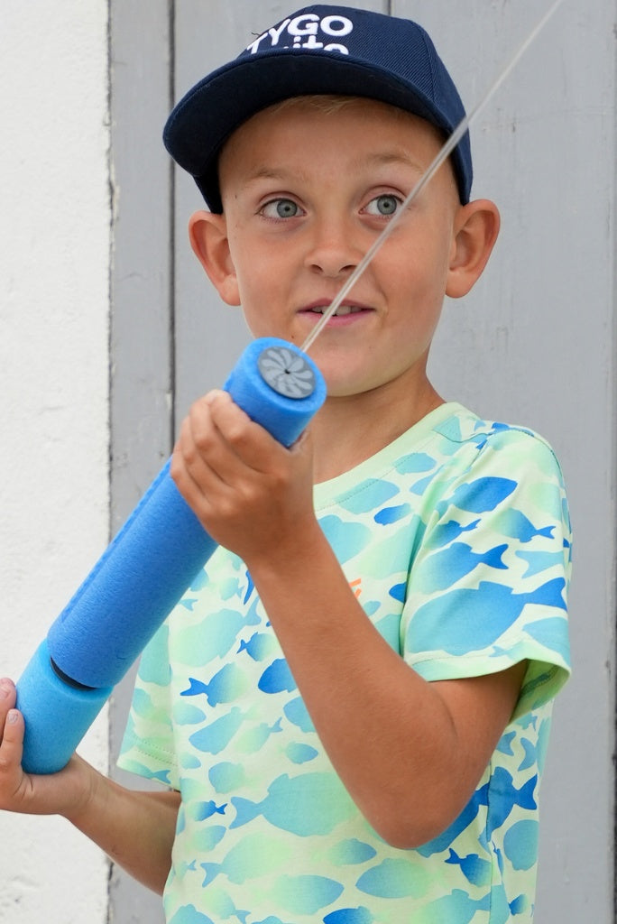 Child holding a blue toy fishing rod with a white background