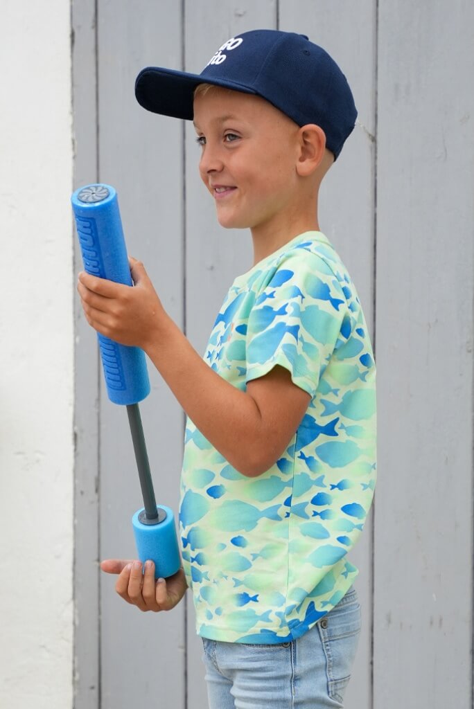 Boy holding a blue pool noodle against a wooden background