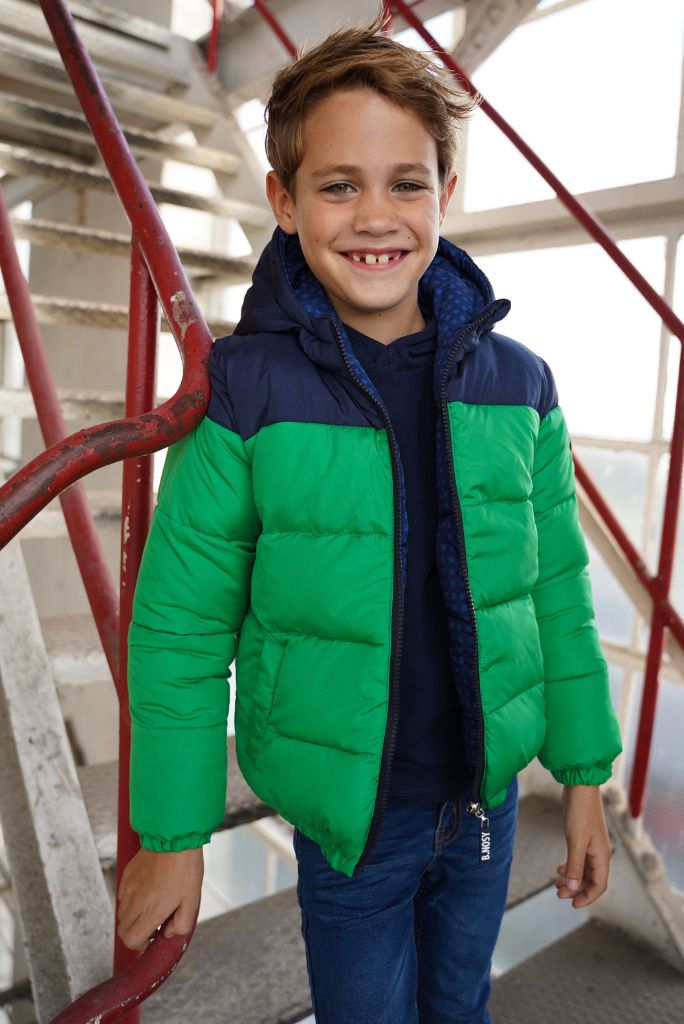 Smiling Boy wearing a reversible puffer jacket