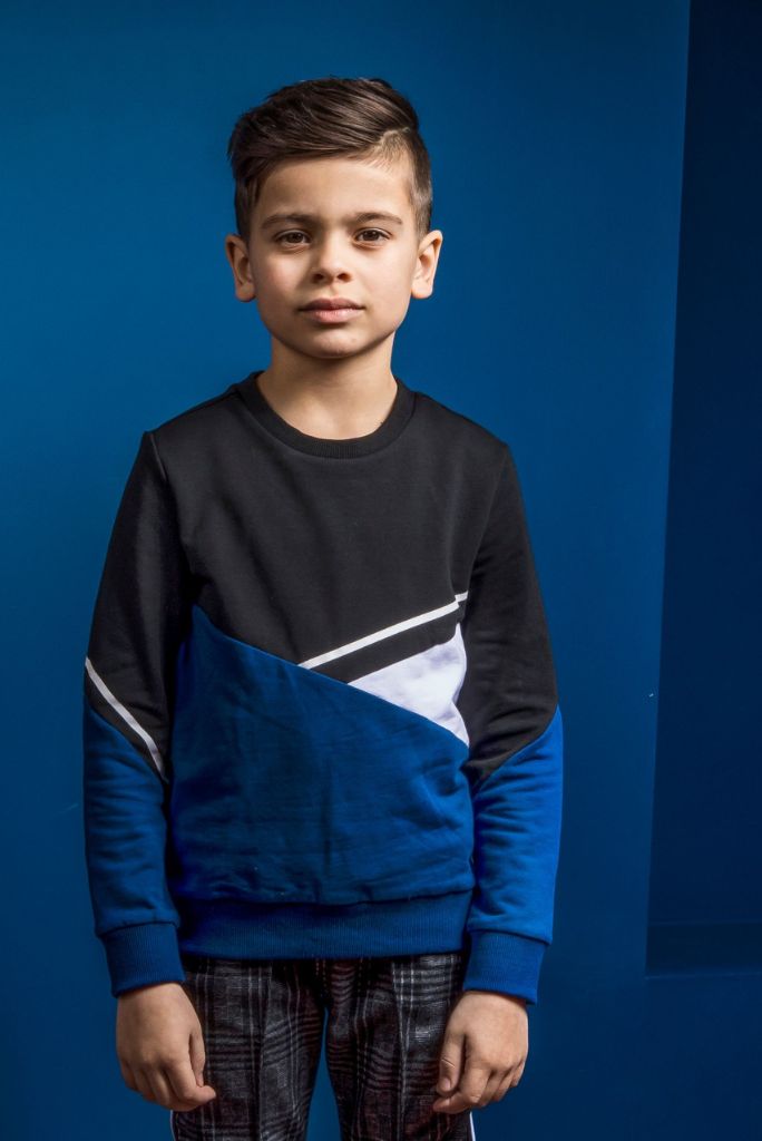 Boy wearing the black jumper with contrast panels and check pants