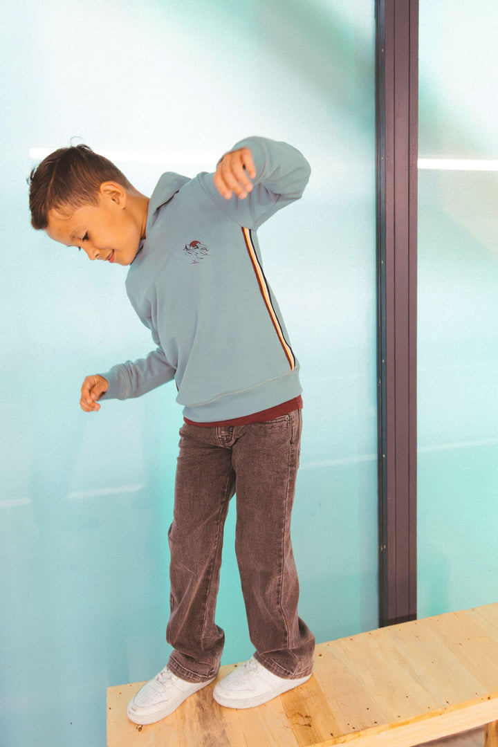 Boy  standing on a wooden platform wearing the Loyd loose fit jeans