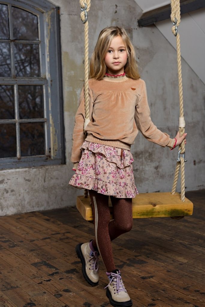 Girl wearing the brown tights with a skirt and standing