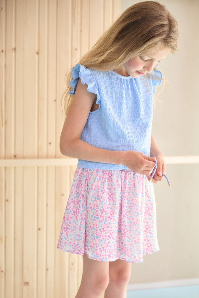 Girl wearing the blue dress Mayke by NONO and looking down.