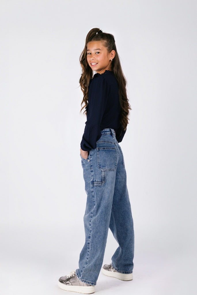 Girl wearing blue jeans and a black top on a white background