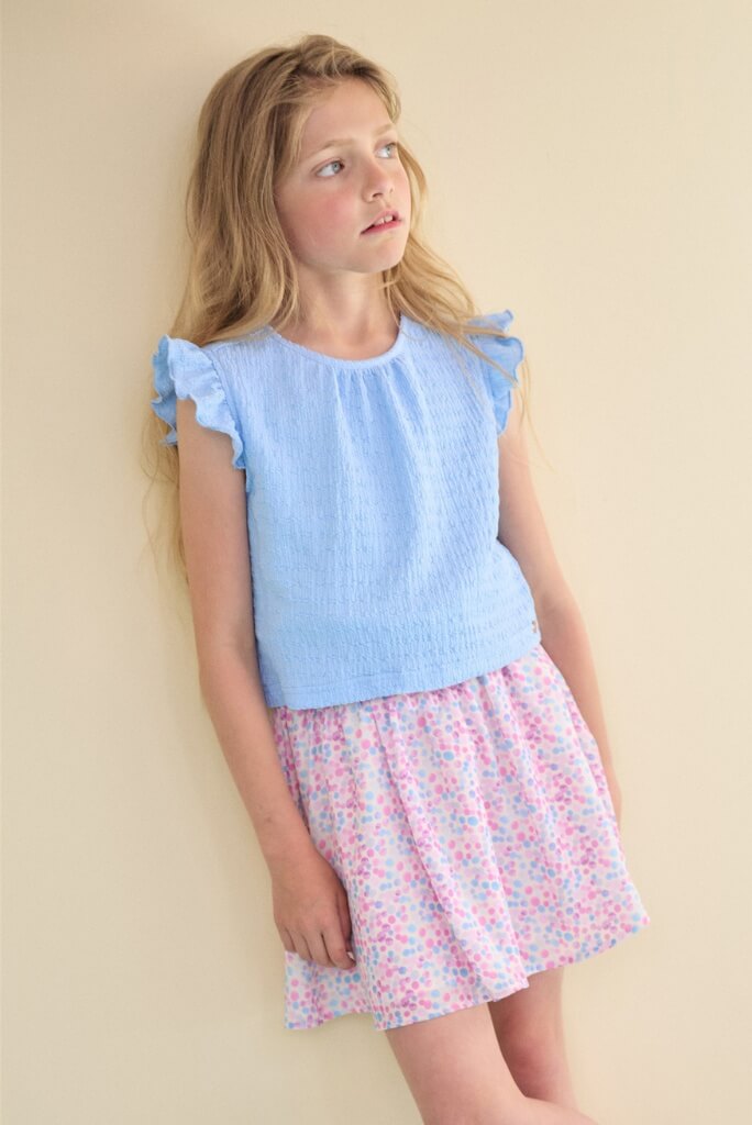 Girl wearing the blue dress Mayke by NONO and looking to the side.