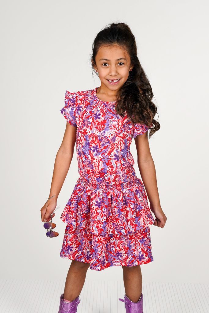 Young girl wearing the colorful floral dress Delphi on a white background
