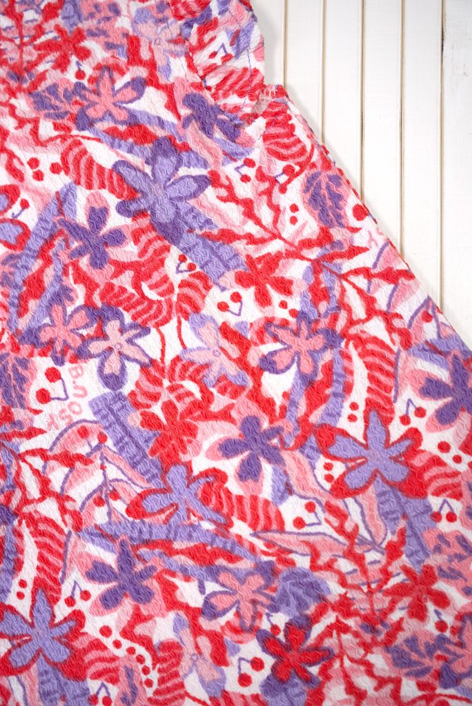 Close-up of a floral patterned top Tamar with red, purple, and white colors.