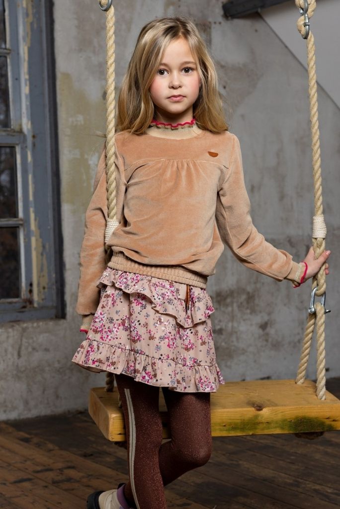 Girl wearing the floral skirt Neva by NoNo on a swing