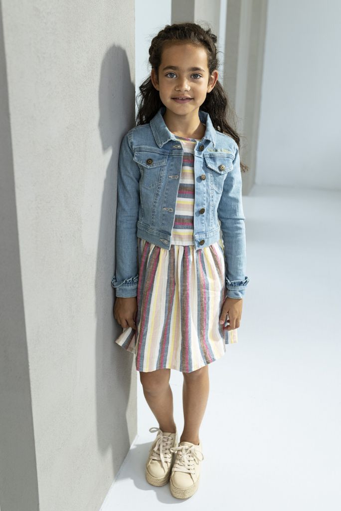 Girl wearing the linen stripe dress by Like FLO with a denim jacket