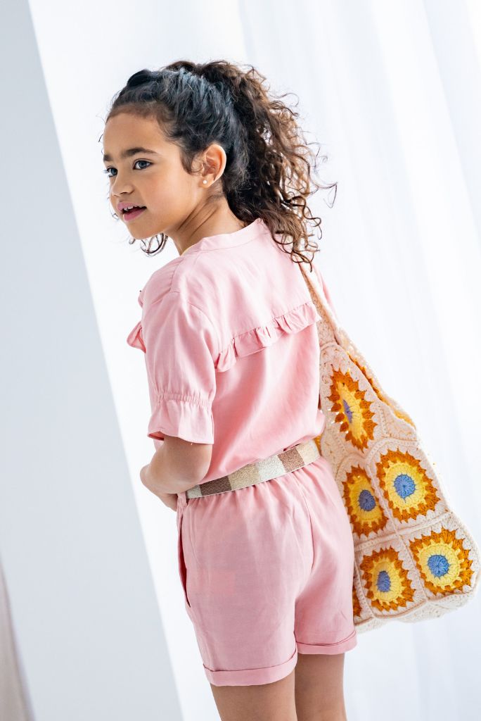 Front view of the girl in the pink linen playsuit