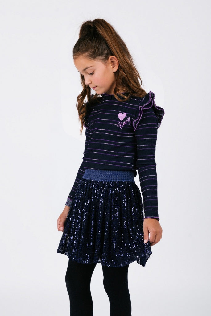 Young girl wearing a dark blue striped long-sleeve top and matching skirt on a white background