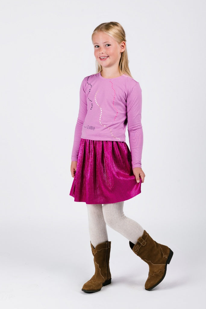 Young girl wearing a pink top and pink skirt with brown boots on a white background
