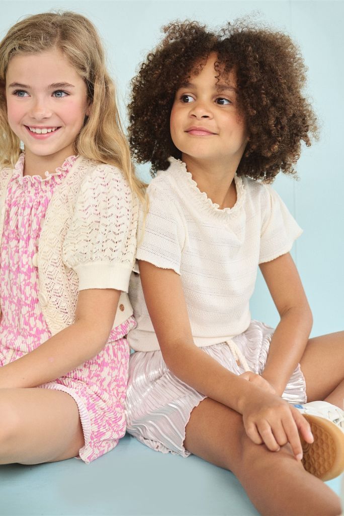 Two girls sitting and wearing the playsuits by NONO
