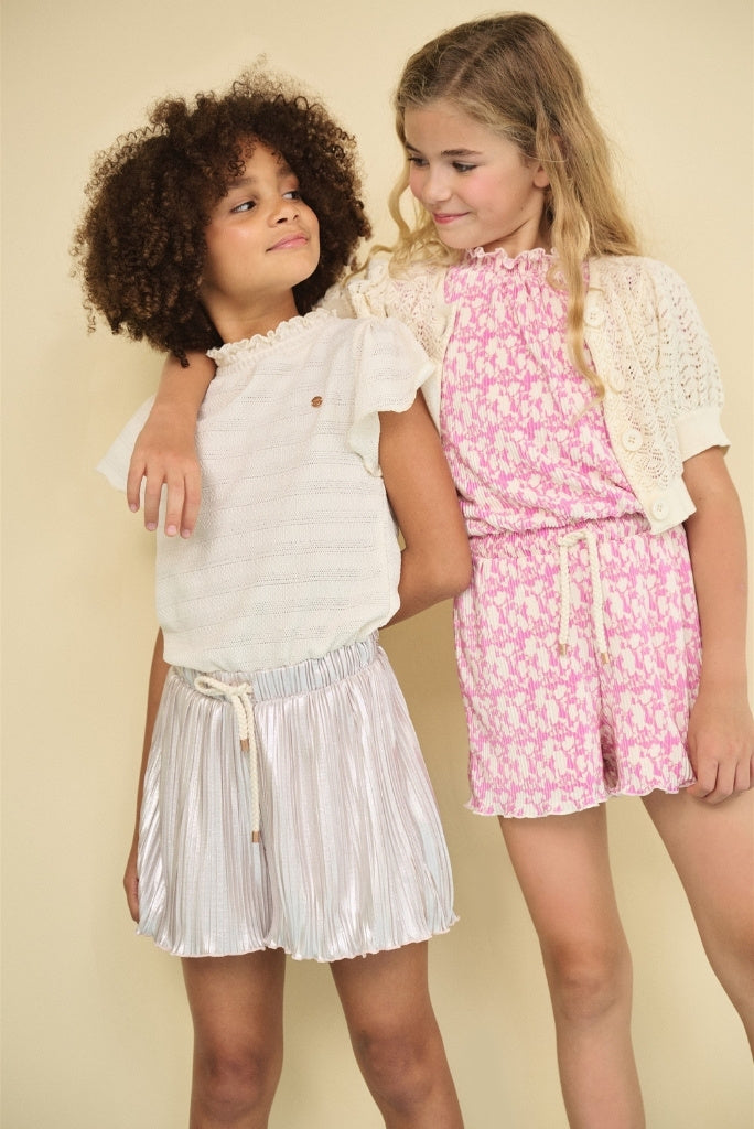 Two girls standing and looking at each other and wearing playsuits by NONO.
