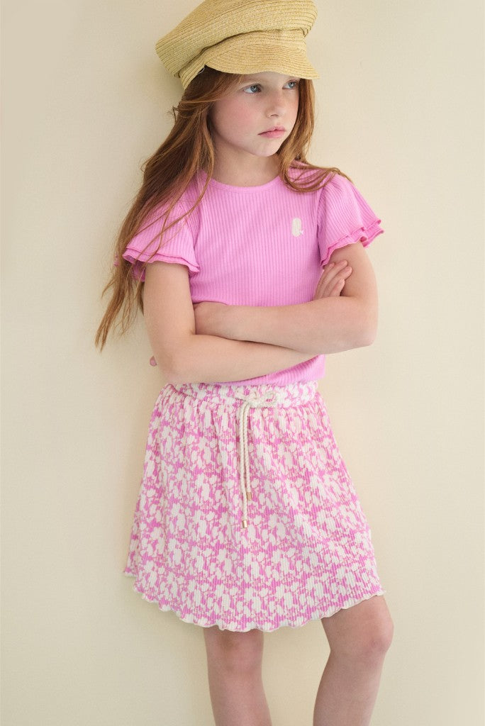 Young girl wearing a pink dress Morly against a beige background