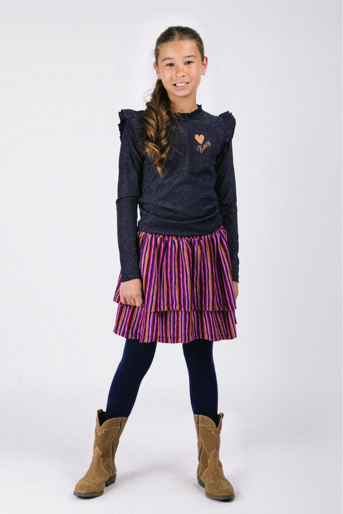 Young girl wearing a dark blue long-sleeve top, striped skirt, black tights, and brown boots on a white background