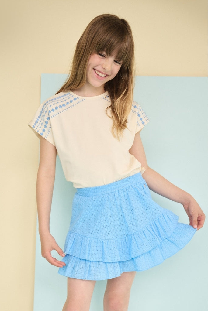 Smiling girl looking down and wearing the ivory top Katy by NONO. 