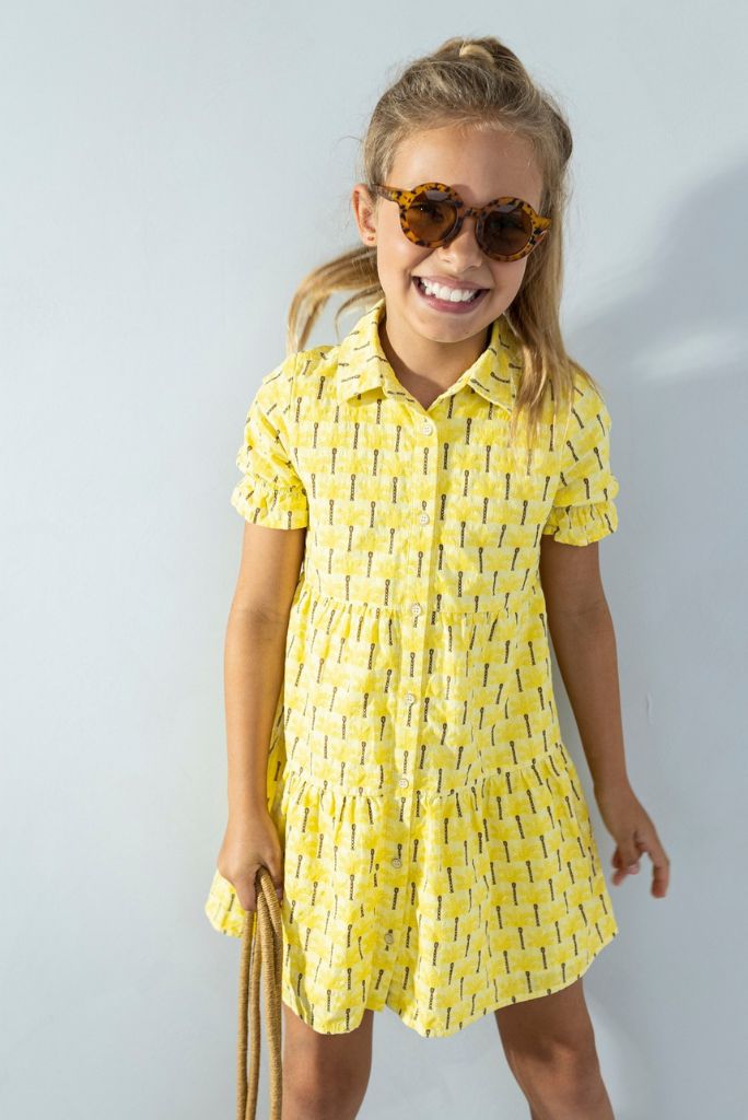 Girl wearing the yellow shirt dress with palm tree print by Like FLO