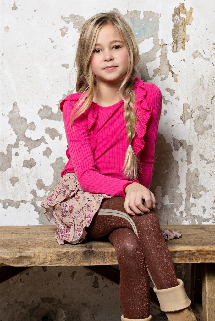 Girl wearing the Neva skirt with flowers sitting on a bench