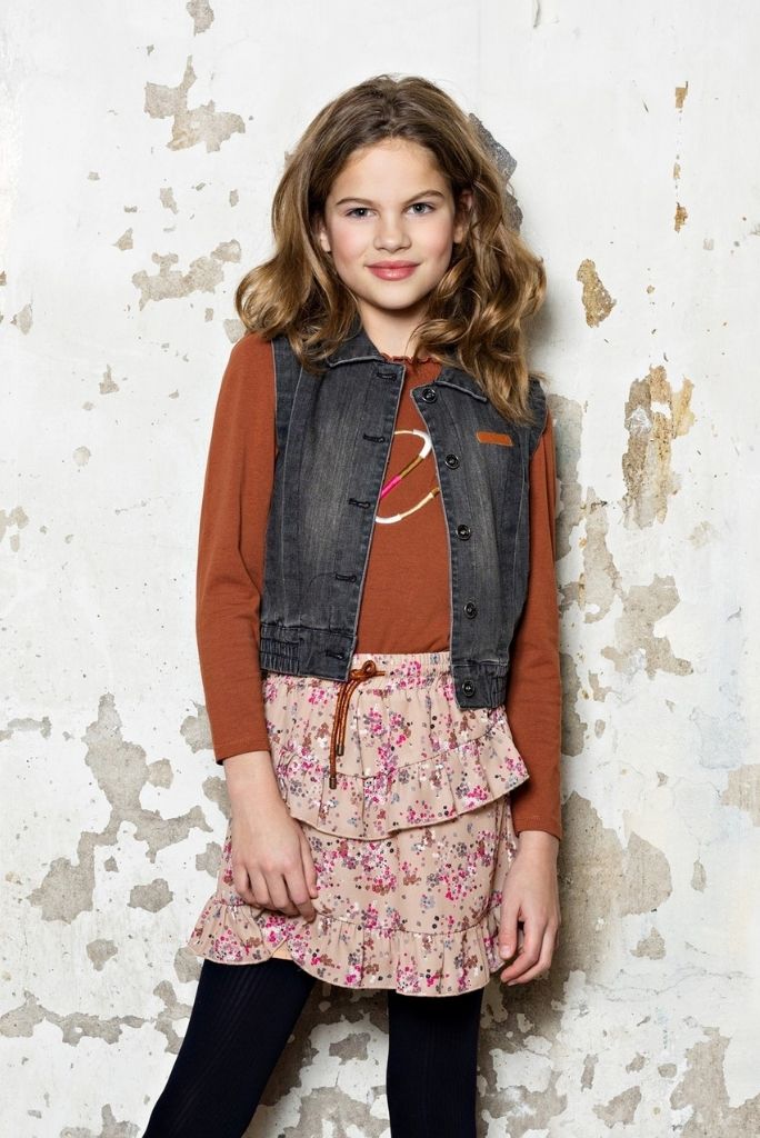 Girl wearing the floral skirt Neva with a brown long sleeve top