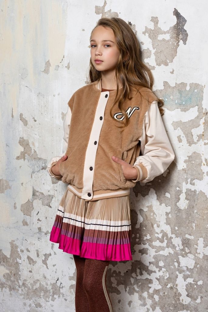 Girl wearing the Nulan pleated skirt with a jacket