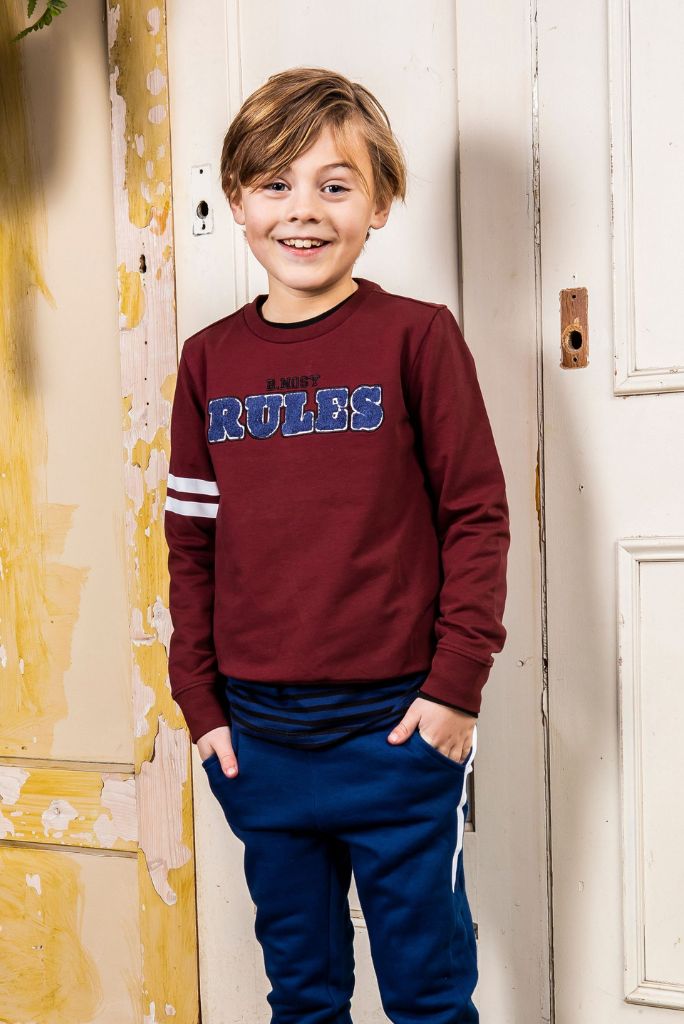 Boy wearing the red boys jumper and smiling