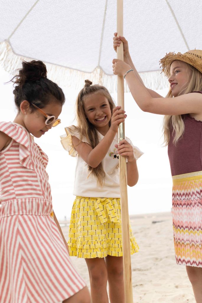 Girl wearing the Like FLO yellow skirt at the beach