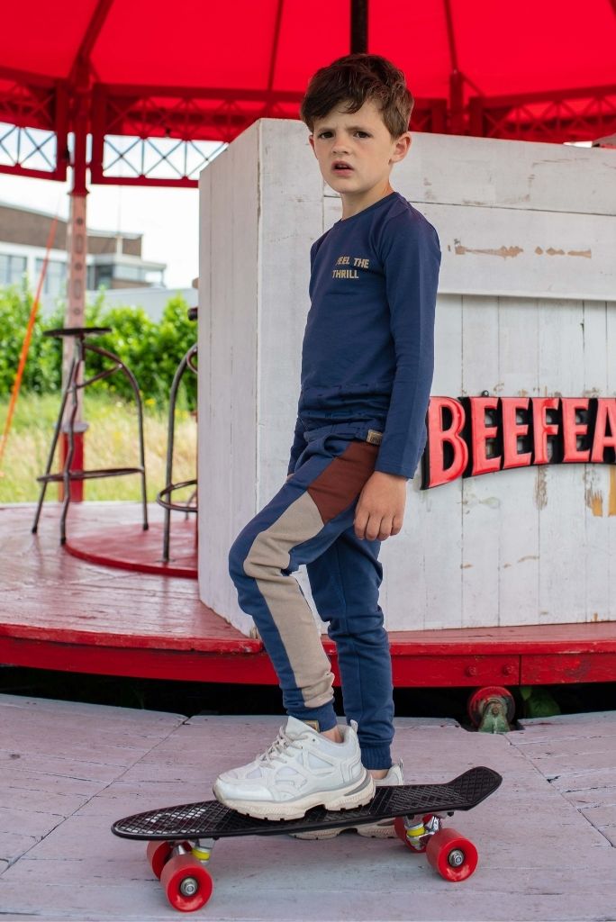 Boy wearing the navy track pants by Quapi and standing up