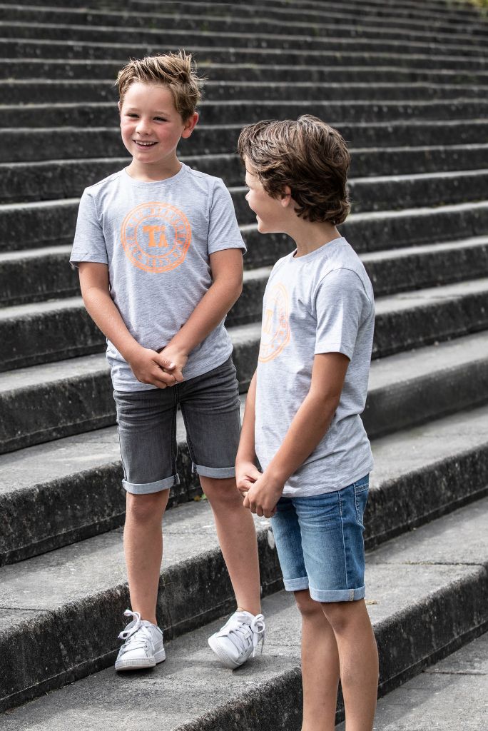 Two boys talking and wearing denim shorts