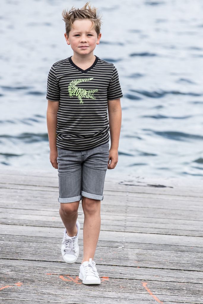 Boy by the water wearing the grey denim shorts